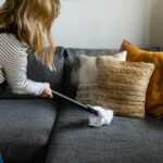 person cleaning sofa