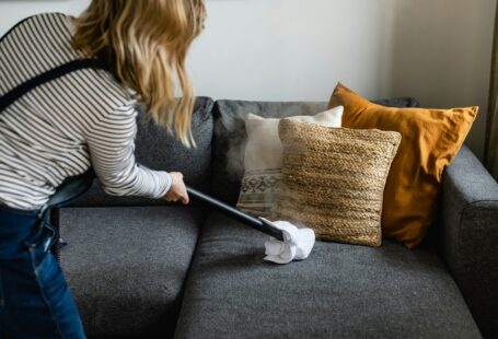 person cleaning sofa