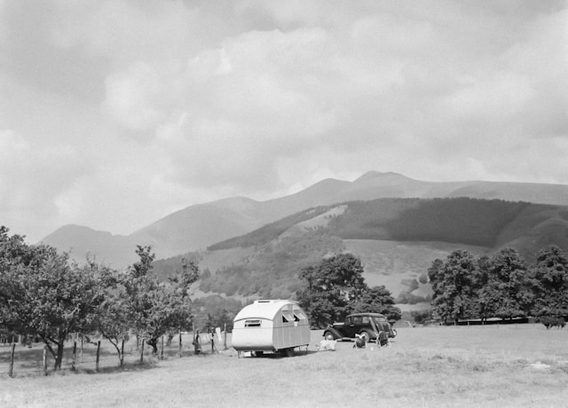 a-black-and-white-photo-of-an-rv-parked-in-a-field