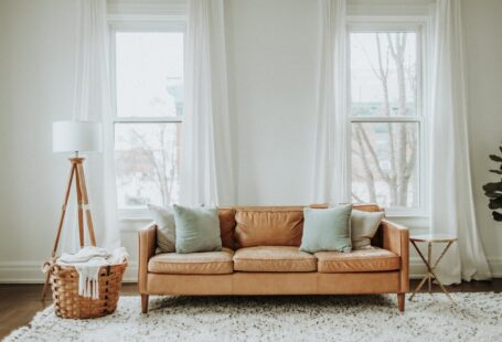 white-and-brown-sofa-chair-near-white-window-curtain