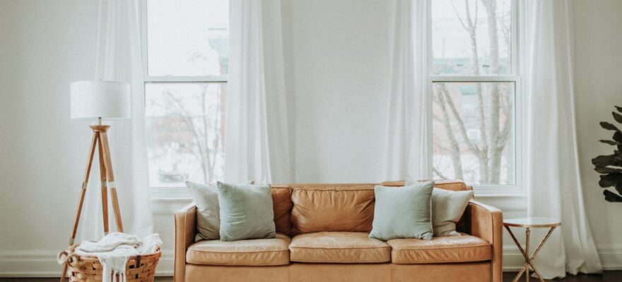 white-and-brown-sofa-chair-near-white-window-curtain