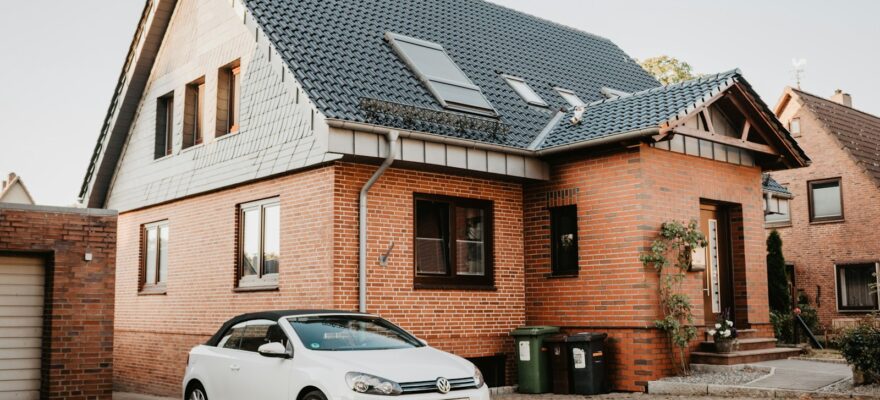 white Volkswagen Jetta parked beside house